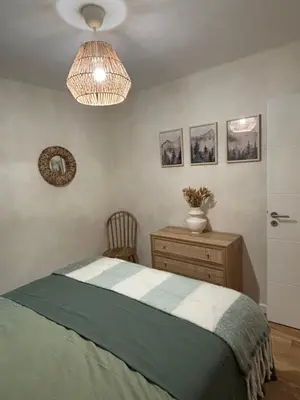 a bedroom with a bed and a dresser and a lamp at appartement chaleureux 60m2 neuf à proximité de tout, proche centre Samoëns in Samoëns