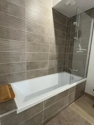 a bathroom with a tub and a glass shower at appartement chaleureux 60m2 neuf à proximité de tout, proche centre Samoëns in Samoëns