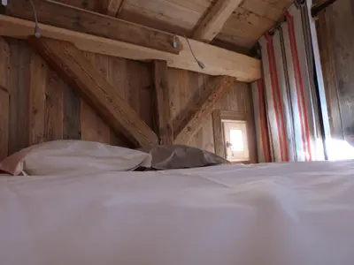 a white bed in a room with wooden walls at La Cubelette in Chamonix-Mont-Blanc