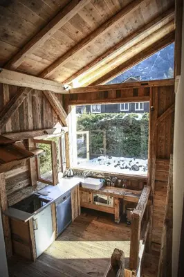 a kitchen in a log cabin with a window at La Cubelette in Chamonix-Mont-Blanc