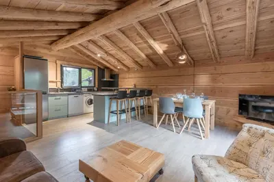 a kitchen and living room with wooden walls at Le Grand Champs - Chalet prive avec terrasse et vue in Chamonix-Mont-Blanc