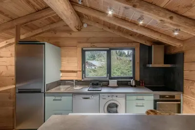 a kitchen with a refrigerator and a dishwasher at Le Grand Champs - Chalet prive avec terrasse et vue in Chamonix-Mont-Blanc