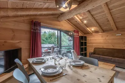 a dining room with a table and a fireplace at Le Grand Champs - Chalet prive avec terrasse et vue in Chamonix-Mont-Blanc