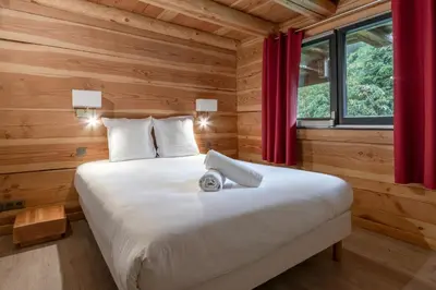 a bedroom with a large bed with red curtains at Le Grand Champs - Chalet prive avec terrasse et vue in Chamonix-Mont-Blanc