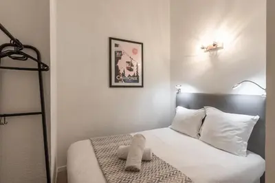 a bedroom with a bed with white sheets and pillows at Duplex - Aiguille du Midi - Centre in Chamonix-Mont-Blanc