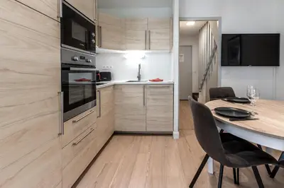 a kitchen with a table and a dining room at Duplex - Aiguille du Midi - Centre in Chamonix-Mont-Blanc
