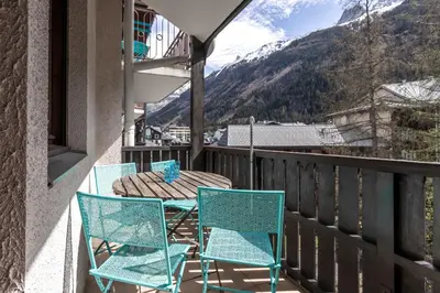 a table and chairs on a balcony with a view at Duplex - Aiguille du Midi - Centre in Chamonix-Mont-Blanc