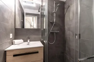 a bathroom with a shower with a sink and a mirror at Duplex - Aiguille du Midi - Centre in Chamonix-Mont-Blanc