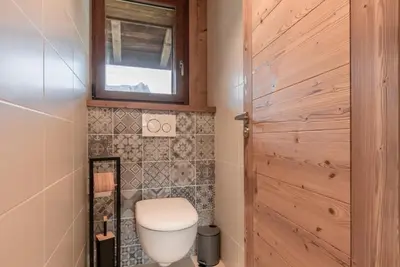 a bathroom with a toilet and a wooden door at Rocher Blanc - Rénové - Spacieux - 4pax in Passy