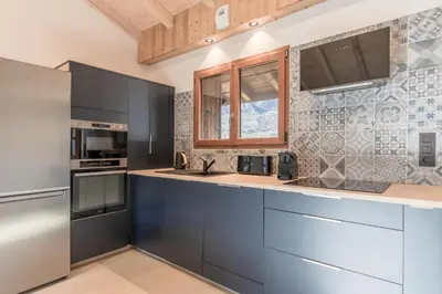a kitchen with stainless steel appliances and blue cabinets at Rocher Blanc - Rénové - Spacieux - 4pax in Passy