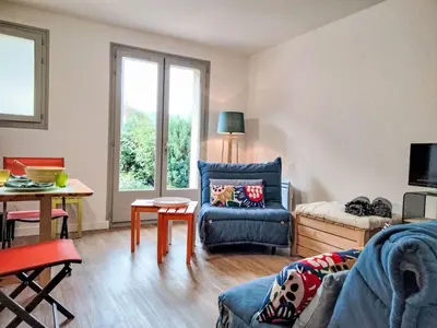 a living room with a blue couch and a sliding glass door at Studio Les cimes blanches by Interhome in Saint-Gervais-les-Bains