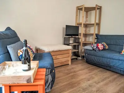 a living room with two blue couches and a tv at Studio Les cimes blanches by Interhome in Saint-Gervais-les-Bains