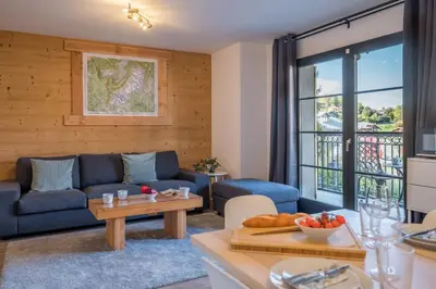 a living room with a blue couch and a table at Apartment Arbois in Saint-Gervais-les-Bains