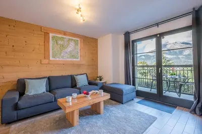 a living room with a blue couch and a table at Apartment Arbois in Saint-Gervais-les-Bains