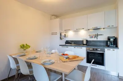 a kitchen with a wooden table and white cabinets at Apartment Arbois in Saint-Gervais-les-Bains