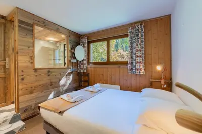 a bedroom with a large bed and a window at Appartement T4 familial à Chamonix, avec Parking et près des Grand Montets in Chamonix-Mont-Blanc