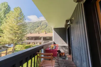 a balcony of a house with a table on it at Appartement T4 familial à Chamonix, avec Parking et près des Grand Montets in Chamonix-Mont-Blanc