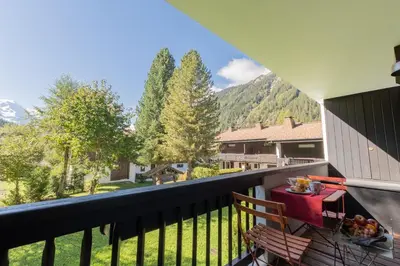 a balcony with a table and a view of the mountains at Appartement T4 familial à Chamonix, avec Parking et près des Grand Montets in Chamonix-Mont-Blanc