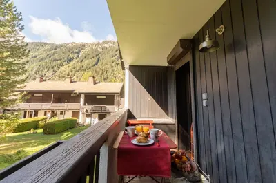 a table with a plate of fruit on a balcony at Appartement T4 familial à Chamonix, avec Parking et près des Grand Montets in Chamonix-Mont-Blanc
