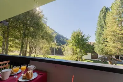 a table with glasses of orange juice on a balcony at Appartement T4 familial à Chamonix, avec Parking et près des Grand Montets in Chamonix-Mont-Blanc