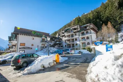 a parking lot with cars parked in the snow at Résidence Le Cristal - Grands Montets 9 - Happy Rentals in Chamonix-Mont-Blanc