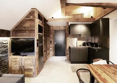 a kitchen with wooden cabinets and a large television at Logement de vacances exclusif - Plein centre in Arâches-la-Frasse