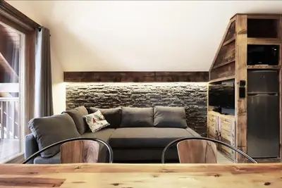 a living room with a couch and a table at Logement de vacances exclusif - Plein centre in Arâches-la-Frasse