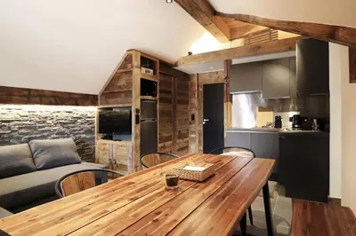 a kitchen and dining room with a wooden table at Logement de vacances exclusif - Plein centre in Arâches-la-Frasse