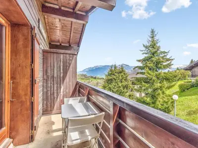 a balcony with chairs and a view of the mountains at Bel appartement au pied des pistes-Megeve in Demi-Quartier