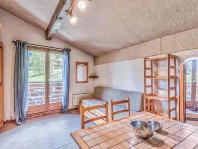 a living room with a table and a couch at Bel appartement au pied des pistes-Megeve in Demi-Quartier