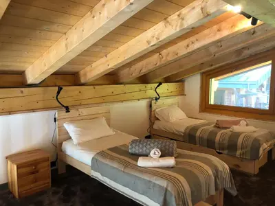 a bedroom with two beds in a log cabin at Mountain Cabin - vue montagne - 4 personnes in Les Houches