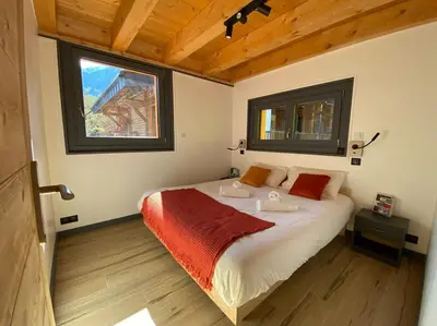 a bedroom with a large bed in a room with a window at Mountain Cabin - vue montagne - 4 personnes in Les Houches