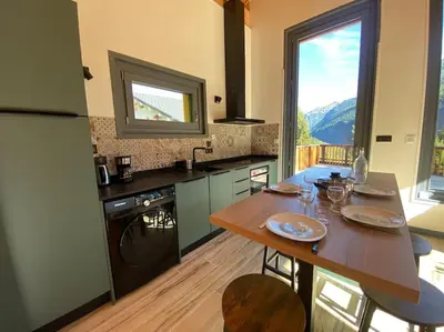 a kitchen with a wooden table and a large window at Mountain Cabin - vue montagne - 4 personnes in Les Houches