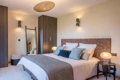 a bedroom with a large bed with blue pillows at Chalet Diane I Luxe I Proche des pistes in Combloux