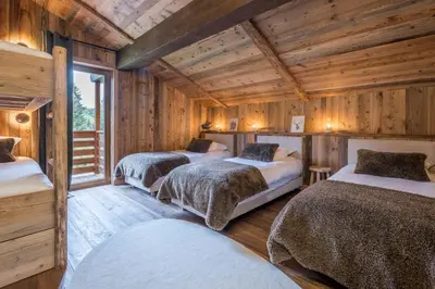 three beds in a room with wooden walls at Chalet Diane I Luxe I Proche des pistes in Combloux