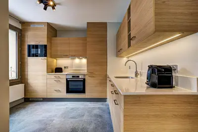 a kitchen with wooden cabinets and a sink at White Pearl - Centre de Chamonix - 2ch - Renove in Chamonix-Mont-Blanc