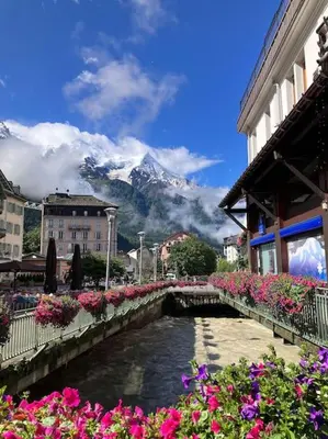 a bridge over a river with a mountain in the background at Magnifique Appartement au Centre de Chamonix in Chamonix-Mont-Blanc