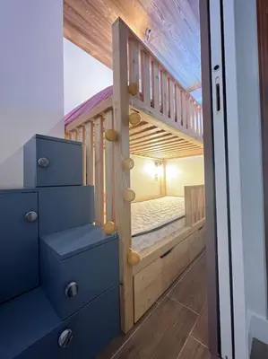 a bedroom with a bunk bed with blue drawers at Megève appartement centre ville palais des sports in Megève
