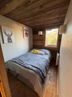 a small bedroom with a bed in a cabin at Duplex aux pieds des pistes à Rochebrune in Megève