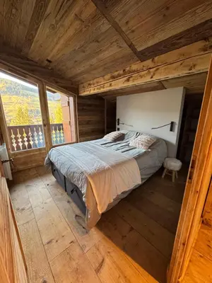 a bedroom with a bed in a wooden house at Duplex aux pieds des pistes à Rochebrune in Megève