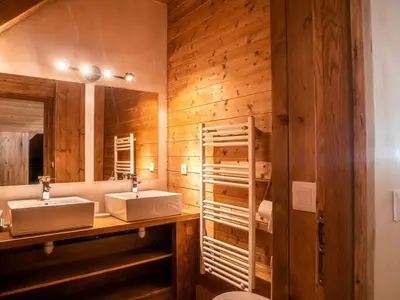 a bathroom with two sinks and a wooden wall at Demi-Chalet en plein coeur de Chamonix - Gabi in Chamonix-Mont-Blanc