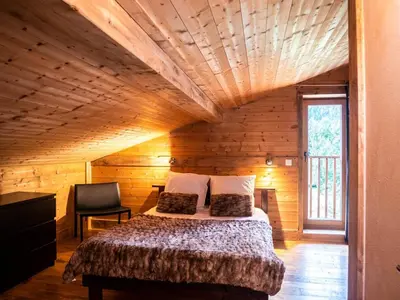 a bedroom with a bed in a wooden cabin at Demi-Chalet en plein coeur de Chamonix - Gabi in Chamonix-Mont-Blanc