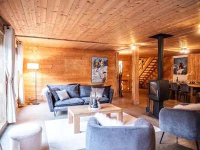 a living room with a blue couch and a tv at Demi-Chalet en plein coeur de Chamonix - Gabi in Chamonix-Mont-Blanc
