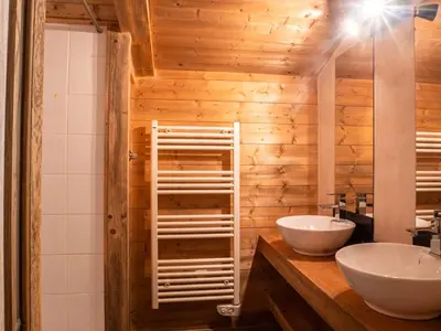 a bathroom with two sinks and a wooden wall at Demi-Chalet en plein coeur de Chamonix - Gabi in Chamonix-Mont-Blanc
