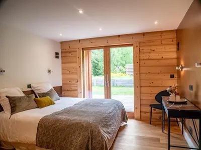 a bedroom with a bed and a sliding glass door at Chalet Bonami 450 m2 salle cinema jacuzzi hammam in Chamonix-Mont-Blanc