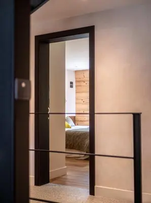 a mirror in front of a room with a bed at Chalet Bonami 450 m2 salle cinema jacuzzi hammam in Chamonix-Mont-Blanc