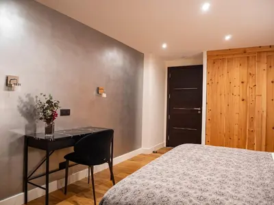 a bedroom with a bed and a table and a desk at Chalet Bonami 450 m2 salle cinema jacuzzi hammam in Chamonix-Mont-Blanc