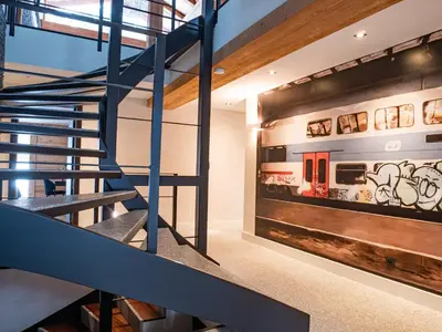 a staircase in a house with a train mural on the wall at Chalet Bonami 450 m2 salle cinema jacuzzi hammam in Chamonix-Mont-Blanc