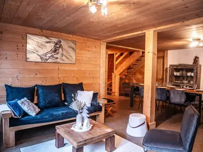 a living room with a blue couch and a table at Demi Chalet au coeur de Chamonix - Zefi in Chamonix-Mont-Blanc