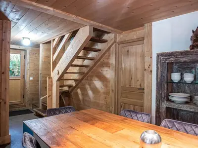 a dining room with a wooden table and stairs at Demi Chalet au coeur de Chamonix - Zefi in Chamonix-Mont-Blanc